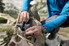 A person is putting a water filter into a backpack while outdoors. Produktbild-Vorschau