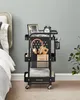 A black rolling cart filled with various items is placed next to a bed in a bedroom. Produktbild-Vorschau