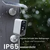 A security camera with a solar panel attached to a wall during a rain shower. Náhled obrázku produktu