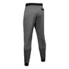 A back view of a pair of gray joggers with black cuffs and waistband. Náhled obrázku produktu