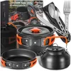 A collection of camping cookware and utensils laid out on a wooden surface, with a box in the background. Náhled obrázku produktu