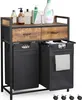 A laundry cart with two drawers and two laundry bags, displayed on a white background with several cleaning products on top. Voir les images du produit