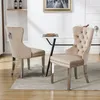Two beige dining chairs are placed around a white marble-topped table in a dining room setting. Podgląd zdjęcia produktu
