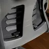 A close-up view of the mesh back and plastic frame of an office chair, showing some of the adjustment mechanisms. Voir les images du produit