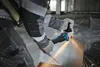 A person is using an angle grinder to cut metal in a construction environment. Náhľad obrázku produktu