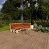 An outdoor seating area with a pallet sofa and coffee table on a wooden deck, surrounded by greenery and trees. Produktbild-Vorschau
