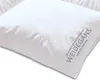 A close-up, angled view of a white down comforter with text printed on the corner. Produktbild-Vorschau