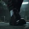 A close-up shot of a black shoe with white socks and dark pants. Náhled obrázku produktu