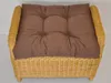 A close-up, top-down view of a brown cushion on a wicker ottoman. Produktbild-Vorschau