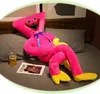 A large pink plush toy is lying on a bed next to a magazine and a glass of beer. Produktbild-Vorschau