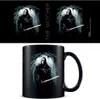 A mug with artwork of Geralt of Rivia from The Witcher, set against a dark, atmospheric background. The top portion of the image shows the artwork repeated, with the title 'THE WITCHER' vertically oriented. Voir les images du produit