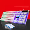 A white gaming keyboard and mouse set with rainbow backlighting, displayed on a black surface against a vibrant red background. Produktbild-Vorschau
