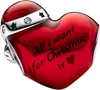 A close-up of a red heart-shaped Christmas charm with engraved text and silver accents. Produktbild-Vorschau