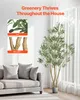 An artificial olive tree is shown next to a sofa in a living room setting. Close-up insets highlight the leaves and trunk bifurcation. Voir les images du produit