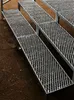 A close-up, angled view of several metal stair sections, likely an outdoor staircase, resting on a dirt or gravel surface. Produktbild-Vorschau