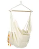 A beige hammock chair with orange tassels hanging from a wooden bar. Produktbild-Vorschau