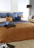 A neatly made bed with multiple pillows and a duvet. Produktbild-Vorschau