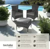 A rattan furniture set with two chairs and a table is displayed on a patio next to a swimming pool. Náhled obrázku produktu