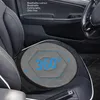 A close-up view of a gray, round car seat cushion with a hexagonal pattern and blue text indicating "360°" is placed on a black car seat. The car's interior, including the door panel and steering wheel, is visible in the background. Produktbild-Vorschau