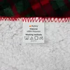 A close-up of a product label attached to a fluffy blanket with a plaid pattern. Produktbild-Vorschau