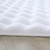 A close-up view of a white, fluffy rug with a wavy, high-low texture, resting on a wooden floor. Anteprima dell’immagine prodotto