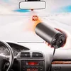 Inside a car on a snowy day, a hand holds a portable car heater pointing towards the windshield. Náhled obrázku produktu