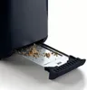 A close-up view of a toaster's crumb tray, which is pulled out and filled with crumbs. Produktbild-Vorschau