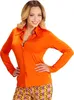 A woman is posing in front of a white background, wearing a bright orange shirt and patterned pants. Produktbild-Vorschau