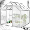 A greenhouse with plants inside, showing gardening tools near the entrance. Náhled obrázku produktu