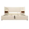 A beige upholstered bed frame with integrated nightstands and reading lights. Náhled obrázku produktu