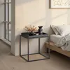 A bedside table with decorative items next to a bed. Produktbild-Vorschau