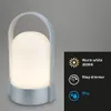 A table lamp with a handle, illuminated, with feature callouts. Anteprima dell’immagine prodotto