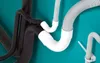 Several flexible corrugated tubes of different colors and sizes are shown connected with white plastic fittings against a teal background. Anteprima dell’immagine prodotto