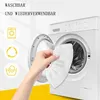 A hand holding a white microfiber cloth in front of an open washing machine. Produktbild-Vorschau