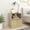 A bedside table with a lamp, books, and a plant. Náhled obrázku produktu
