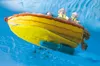 A toy boat with figures on it sailing on blue water. Podgląd zdjęcia produktu