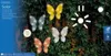 Several butterfly-shaped solar garden lights are attached to a vine-covered fence. Podgląd zdjęcia produktu