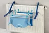 A clothes drying rack is attached to a radiator, with clothes hanging on it. Produktbild-Vorschau