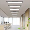 An office environment with modern desks, chairs, and computers, illuminated by several rectangular LED ceiling lights. Produktbild-Vorschau