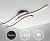 A modern LED ceiling lamp with curved light elements, shown against a white ceiling. Icons indicating texture, LED technology, and warm white light (3000K) are displayed at the bottom. Anteprima dell’immagine prodotto