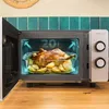 A roasted chicken with potatoes inside a microwave oven. Produktbild-Vorschau
