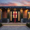 A house entrance decorated for Christmas with a large red bow on the door and falling snow. Náhled obrázku produktu