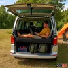 A man is using a laptop inside a van that has been converted into a camper, with camping gear and a tent visible outside. Voir les images du produit