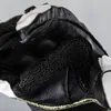 A close-up view of a black and white motorcycle glove, focusing on the textured material and stitching. Podgląd zdjęcia produktu