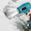A hand holding a teal and black cordless leaf blower, blowing snow off a surface. Produktbild-Vorschau