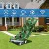 A camouflage lawn mower cover is draped over a lawn mower on a grassy lawn in front of a house. Produktbild-Vorschau