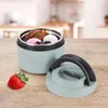 A mint green thermos with ice cream and berries inside, placed on a wooden table next to a strawberry. Voir les images du produit