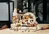 A wooden marble run model with several metal marbles scattered in front of it, set on a surface covered in wood shavings. Produktbild-Vorschau