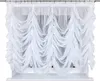 A white sheer curtain with gathered fabric hangs in front of a window. Produktbild-Vorschau