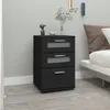 A black nightstand with three drawers is placed next to a bed in a bedroom. Produktbild-Vorschau